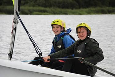 Twee meisjes zeilen samen op een zeilboot op een meer